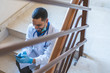 © MCStock - Doctor Using Cellphone at Hospital Stairs on His Work Brake .