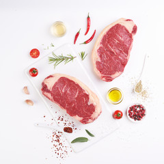 Two striploine steak uncooked on white background with copyspace around