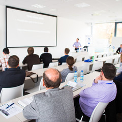 people in a conference room listening to a speech
