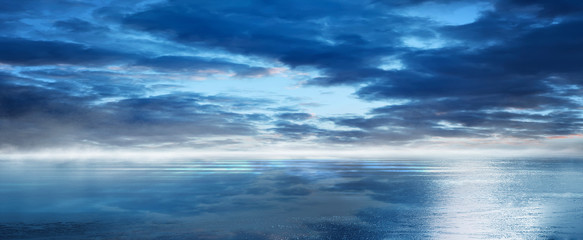 Night seascape. Dark landscape with a marine background and sunset, moon. Abstract night landscape in blue light. Reflection of the moon in the night water. Empty futuristic landscape.