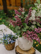 Details of tables decorated in the spring garden for a photoshoot or wedding reception with lilac. Vase with lilac flowers