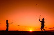 © Jurga Jot - Father and son playing badminton in the evening, silhouettes of people exercising in nature, recreation, sport, lifestyle concept