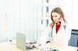 © Masato - Female beautiful wearing a doctor uniform using a notebook computer and talking case of treatment.