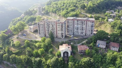 Wall Mural - Old rusty and functioning ropeway or cable car cabins in Chiatura. Panorama of the city district and apartment buildings on the rock and Upper cable car station Perevisa.