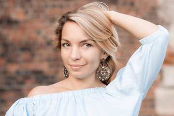 Portrait of a beautiful uninhibited girl with iron boho-style earrings in the summer on the street.