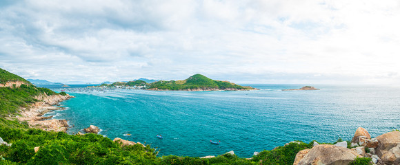 Expansive view of scenic tropical bay, lush green woodland and blue waving sea. The easternmost coast in Vietnam, Phu Yen province between Da Nang and Nha Trang.