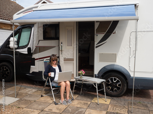 Fotomural A lady motor home owner is parked on her drive unable to travel due to lockdown