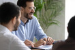 © fizkes - Close up happy laughing businessman with documents have free time in boardroom at meeting break. Handsome male laughter mentor at presentation new project. Manager listening funny joke.