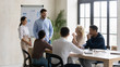 © fizkes - Smiling businessman and businesswoman flip charts presentation new project in boardroom at company meeting. Male and female auditors speaks with diverse partners about business using board and graphs.