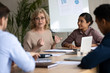 © fizkes - Mature 60 year old businesswoman with indian ethnic partner talking in boardroom at meeting. Confidence woman training diverse corporate team at briefing. Young employee share thoughts sitting.