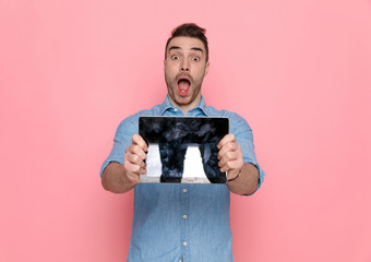 Poster - casual man showing his tablet and opening his mouth