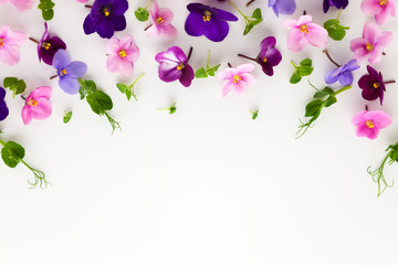 Wall Mural - Spring or summer flower composition with edible  violets and micro greens on white background. Flat lay, copy space. Healthy life and flowers concept.