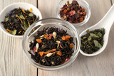 Fototapeta Mapy - A variety of dry tea in cups with pieces of dried fruit, berries and flowers. The concept for the advertisement of tea and the tea ceremony.