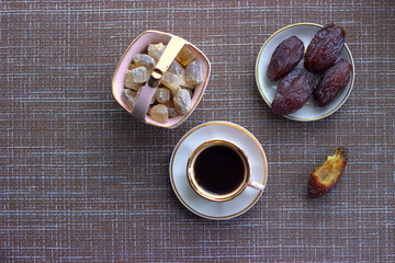 
Vintage espresso cup next to a bowl of cane sugar and royal dates