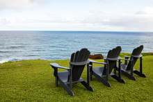 A Group Of Lawn Chairs On A Bluff Next To The Pacific Ocean On The Island Of Kauai In Hawaii. 