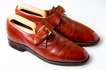 Men's shoes in chestnut color with wooden pads on a white background