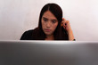 © Antonio Tanaka - Young Hispanic woman in black clothes doing home office with a white laptop in her dining room, typing and looking at her laptop