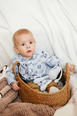 Wall Mural - A small boy is sitting in a wicker basket