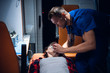 © Anna Kosolapova - Young corpsman applies an oxygen mask to an injured woman lying on a stretcher in an ambulance car