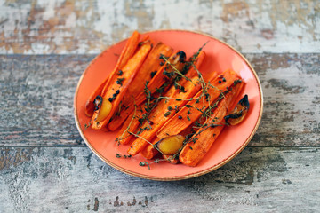 Wall Mural - Selective focus. Plate with baked carrots. Baked carrots with herbs and spices. Vegan lunch. Healthly food. Eco food. Cooking healthy food at home.