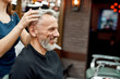 © Svitlana - I like it. Happy mature bearded man smiling while female barber making haircut for him, he is sitting in barbershop