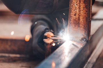 Close-up of the welding process of two metal parts. Industrial background .