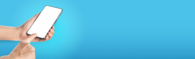 Poster - mockup hand touch on mobile blank screen on blue background in banner size for display of content to advertise on online media.technology background..clipping path on both hand and phone screen