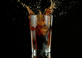 Splashing cola drink on black background