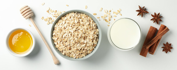 Wall Mural - Composition with oatmeal flakes on white background, top view. Cooking breakfast