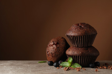 Sticker - Delicious tasty muffins against brown background. Sweet food