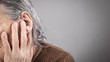 Elderly woman suffering from ear pain.