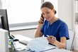 © Syda Productions - medicine, technology and healthcare concept - happy smiling female doctor or nurse with computer and clipboard calling on phone at hospital