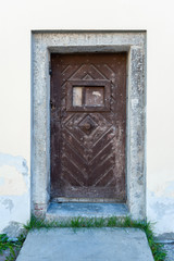 Poster - Old wooden door close-up on a background of a wall .