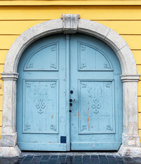 Poster - Old wooden door close-up on a background of a wall .