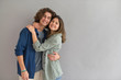 © goodluz - Young couple standing on grey background