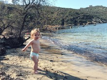 Full Length Of Shirtless Baby Girl Standing At Beach