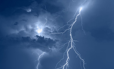 lightning strikes between stormy clouds.