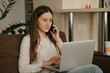 © Roman Tyukin - Remote work. A caucasian woman studying remotely on her laptop. A lady with long hair calling from home.