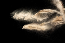 Brown Sand Explosion Isolated On Black Background. Freeze Motion Of Sandy Dust Splash.Sand Texture Concept.