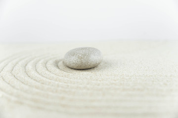 Zen garden. Pyramids of white and gray zen stones on the white sand with abstract wave drawings. Concept of harmony, balance and meditation, spa, massage, relax.