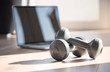 © Tamara - Composing with dumbbells and laptop at home standing for online fitness classes