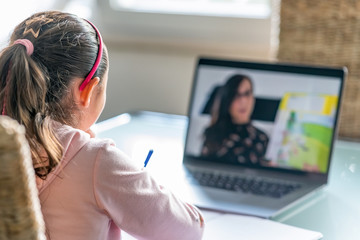 Cute and happy little girl childr using laptop computer, studying through online e-learning system