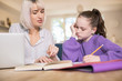 © Daisy Daisy - Female Home Tutor Helping Young Girl Struggling With Studies Or Home Schooling