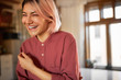 © Anatoliy Karlyuk - Close up image of happy charming young Caucasian woman with pinkish bob hairstyle enjoying nice time indoors, posing in cozy stylish living room with window in background, laughing, having fun