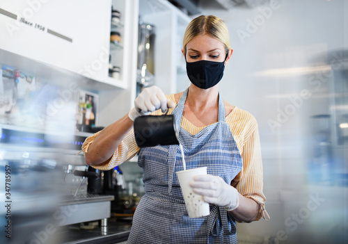Fotografía Coffee shop woman owner working with face mask, open after lockdown quarantine