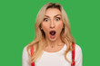 I can't believe this! Closeup portrait of funny amazed adult blond woman standing with wide open mouth and shouting in surprise, shocked expression. indoor studio shot isolated on green background