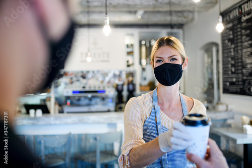 Fotomural Woman with face mask serving customer, shop open after lockdown quarantine