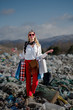 © Halfpoint - Modern woman on landfill, consumerism versus pollution concept.