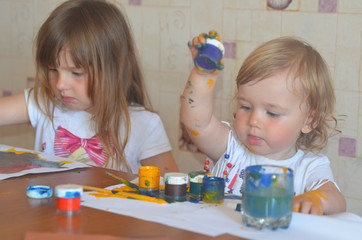 Two caucasian sisters are drawing with paints and home education. The concept of stay home during coronavirus and quarantine