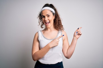 Sticker - Beautiful sportswoman with curly hair wearing sportswear over isolated white background smiling and looking at the camera pointing with two hands and fingers to the side.